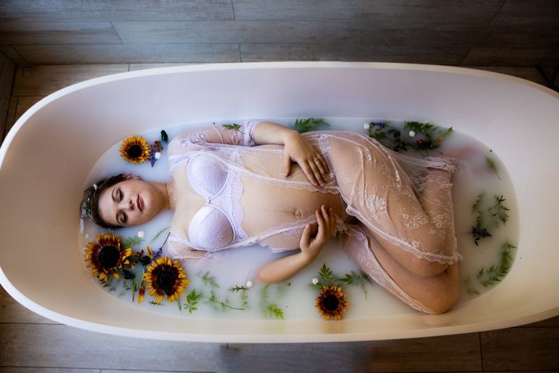High angle view of young pregnant woman in milk bath