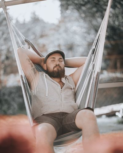 Midsection of man sitting on hammock