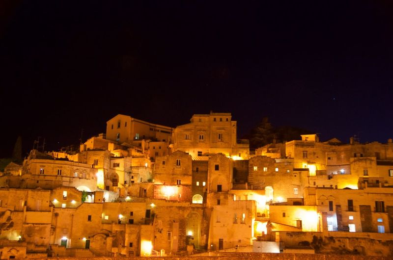 Illuminated town against sky at night