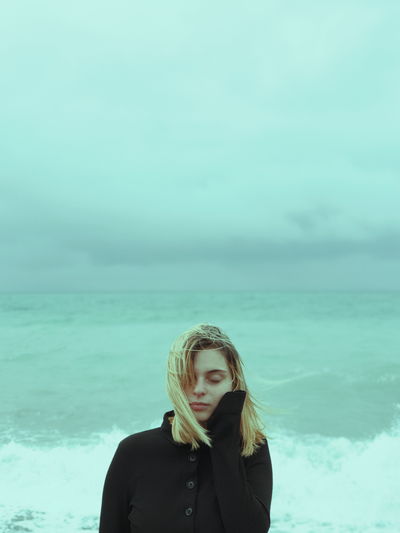 Portrait of mature man standing against sea