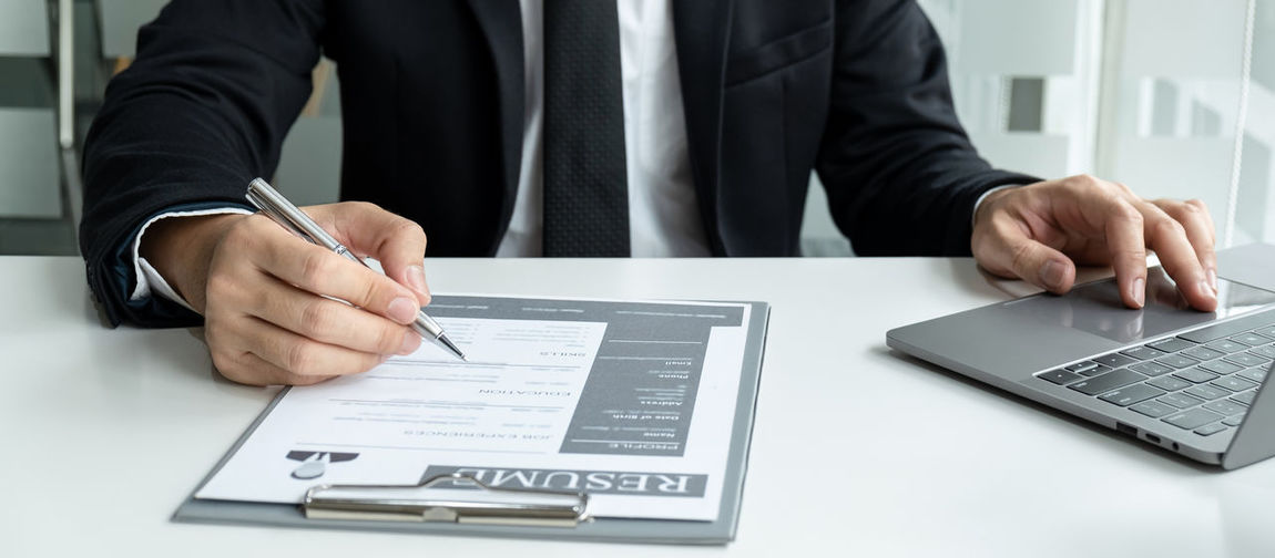 Midsection of businessman writing on document