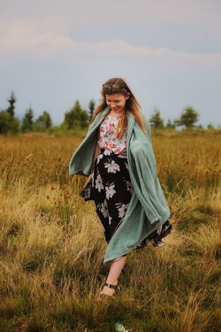 Woman standing on field against sky