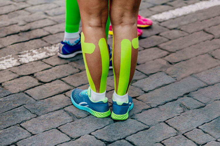 Kinesio tape on calf muscles female runner before marathon