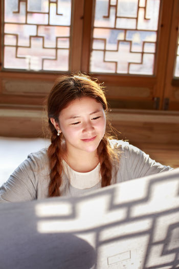 High angle view of smiling girl looking at paper