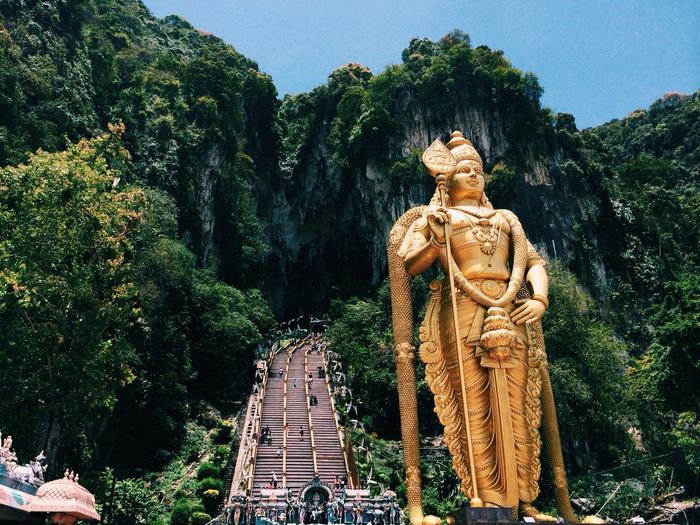 Low angle view of lord murugan statue at batu caves against clear sky