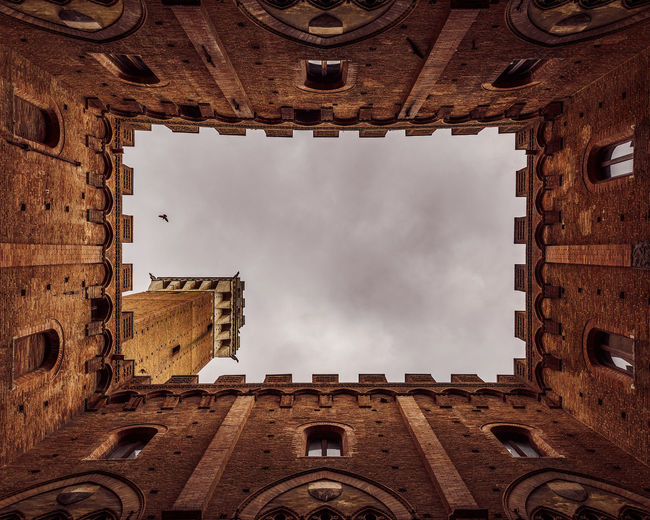 Directly below shot of historic building against cloudy sky