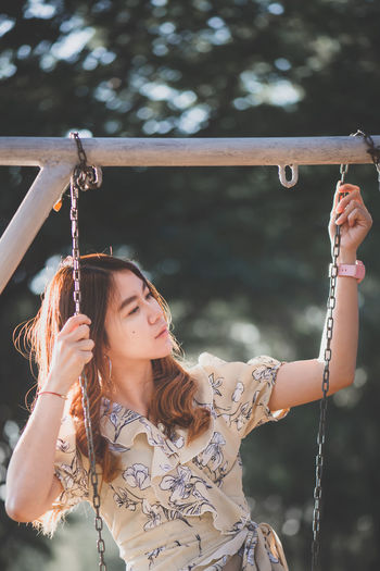 Young woman holding swing chain
