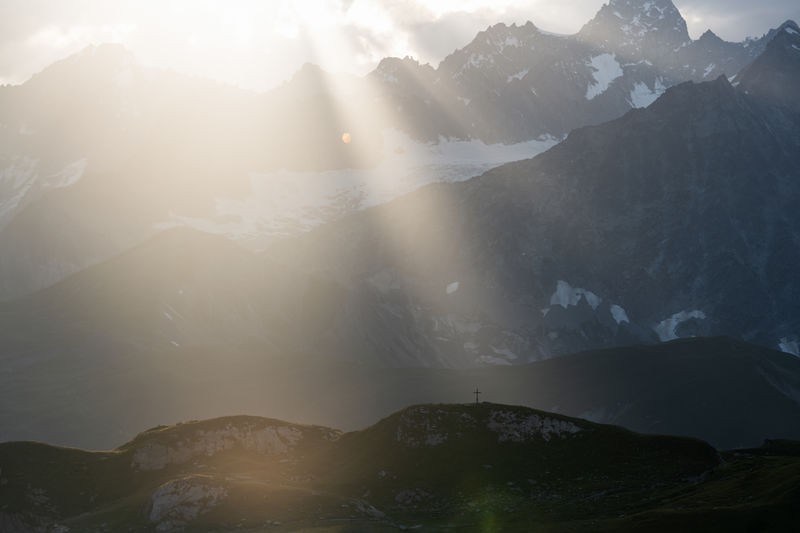 Sunbeam shining on christian cross in the mountains