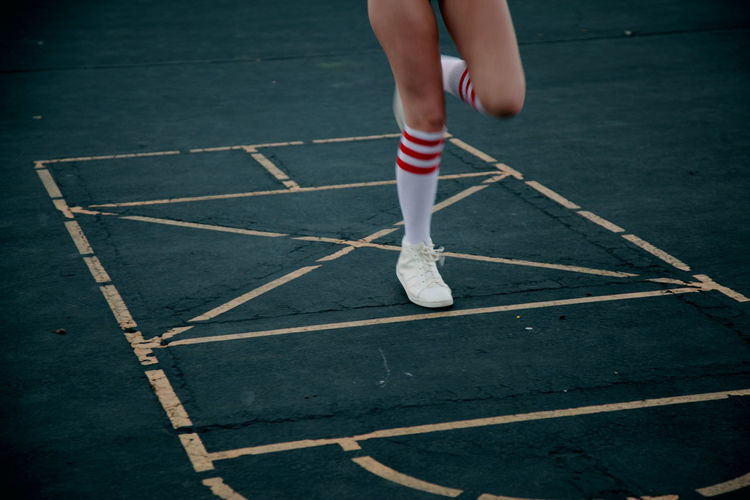 Low section of woman playing hopscotch