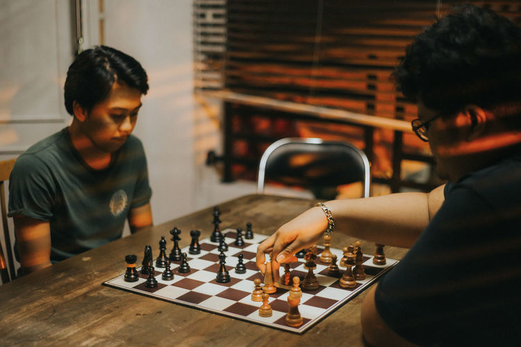 Young man playing with chess in background