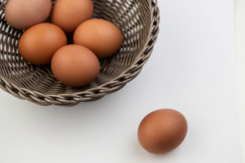 High angle view of eggs in basket on white background