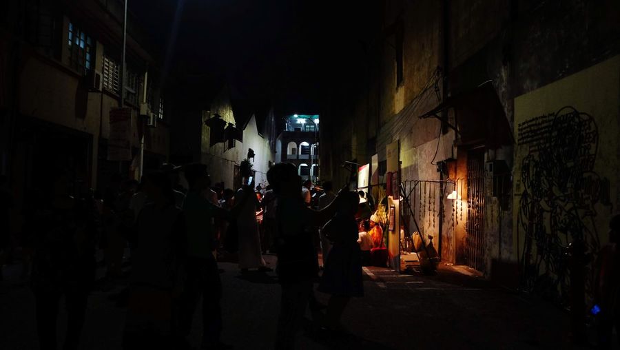 People walking on illuminated street at night