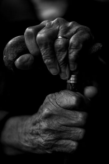 Close-up of man holding cigarette over black background