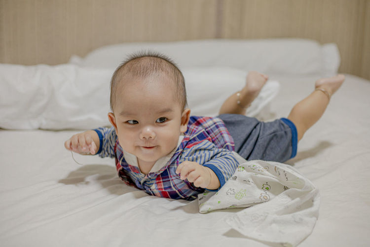 Portrait of cute baby lying on bed