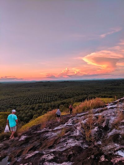 People on field against sky during sunset