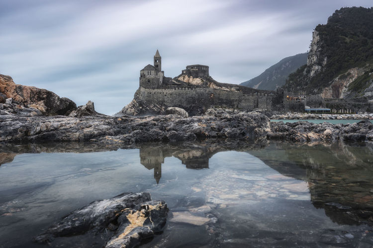 The church of san pietro in portovenere is mirrored on the island of palmaria, italy.