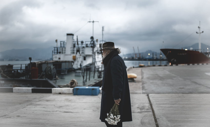Cloud - Sky Commercial Dock Day Focus On Foreground Full Length Harbor Hardhat Helmet Men Mode Of Transport Moored Nature Nautical Vessel Occupation One Person Outdoors People Real People Rear View Sea Ship Shipyard Sky Standing Transportation