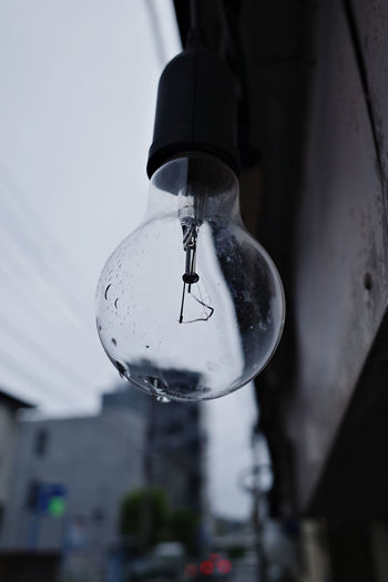Close-up of light bulb hanging from ceiling