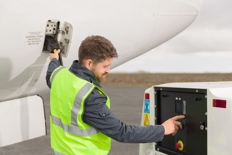 Male technician refueling aircraft on airfield