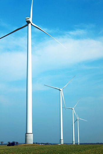 Windmills on field against sky