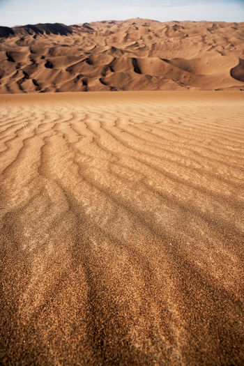 The formation of sands in dasht e lut or sahara desert with waved sand pattern on sand dune. 