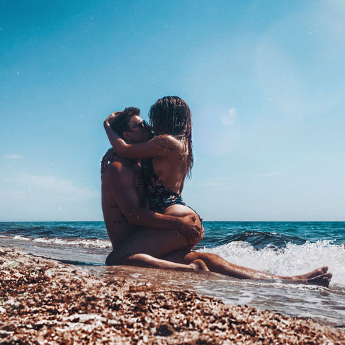 Couple at beach against sky