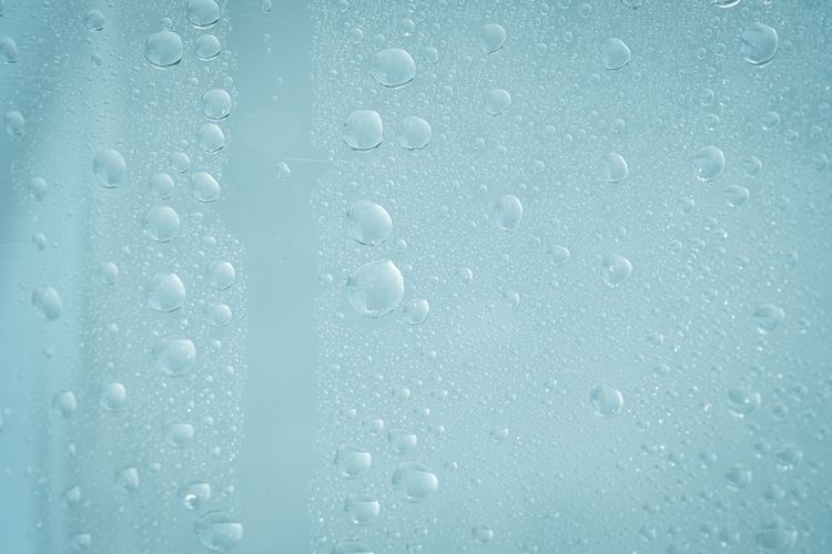 Cool beverage backdrop, light blue background and water droplet on surface.