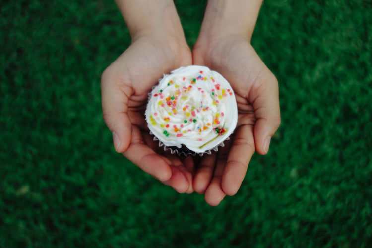 Cropped hands holding cupcake