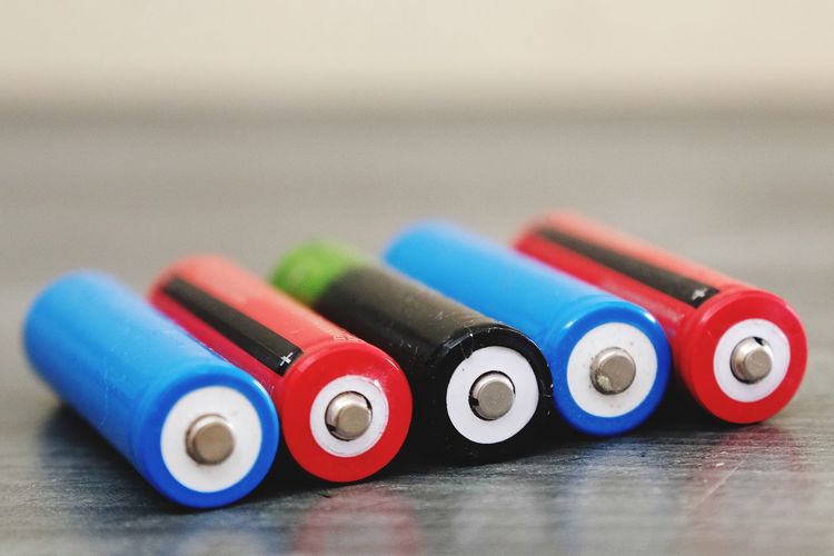 Close-up of colorful batteries on wooden table