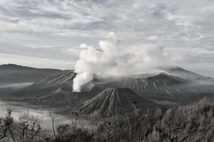 Smoke emitting from volcanic mountain against sky