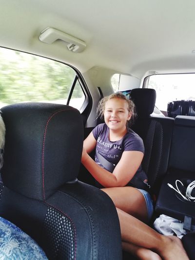 Portrait of smiling girl sitting in car