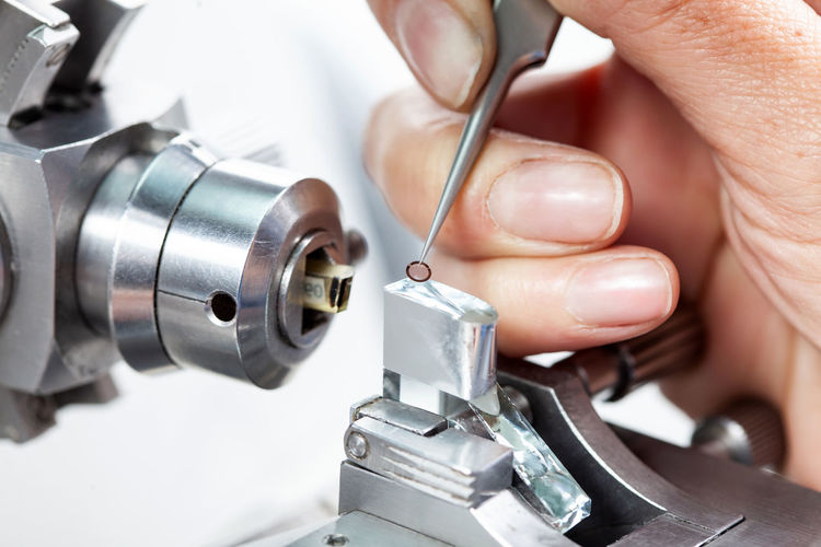 Cropped hand holding sewing machine part