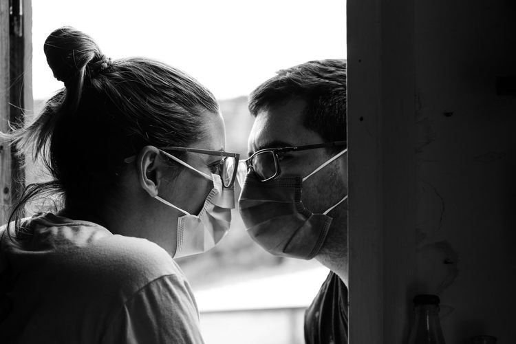 Close-up portrait of couple wearing masks looking at each other 