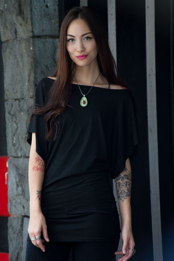 Portrait of woman standing against wall