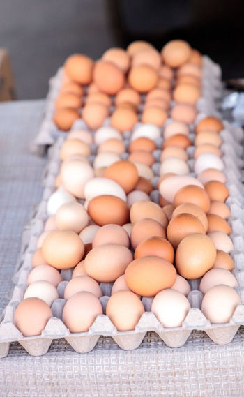 Egg crates of brown and white eggs at a local farmers market from organic chickens.