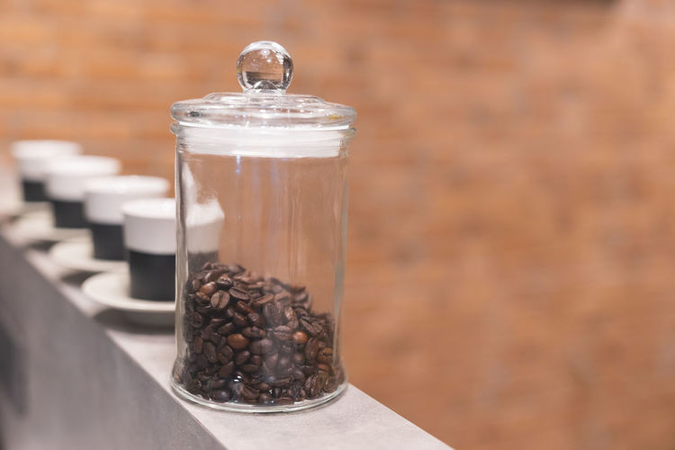 Close-up of coffee beans in glass jar on table