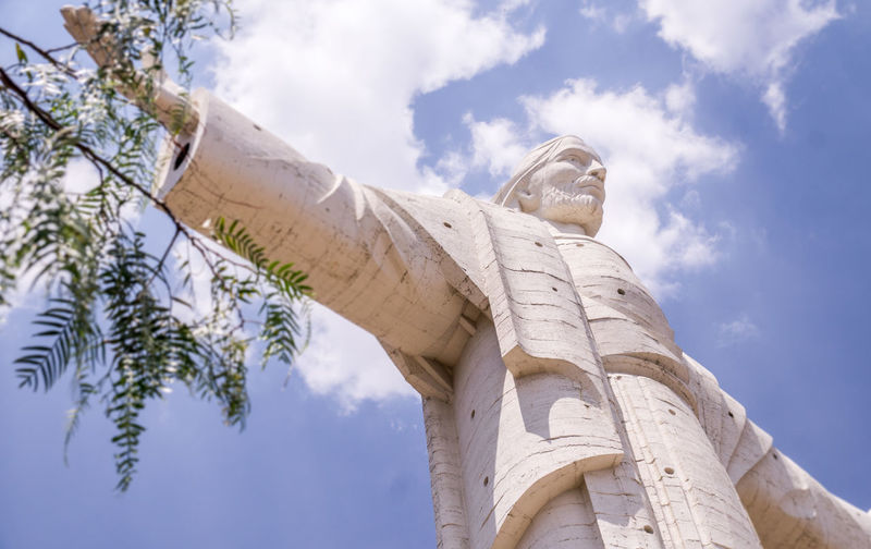 Low angle view of statue against trees and sky