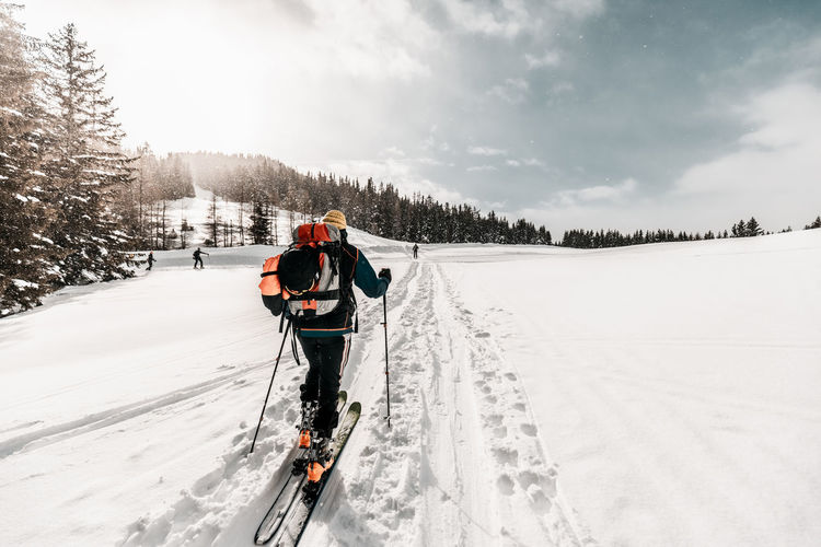 Active senior man skiing on snow covered land during vacation