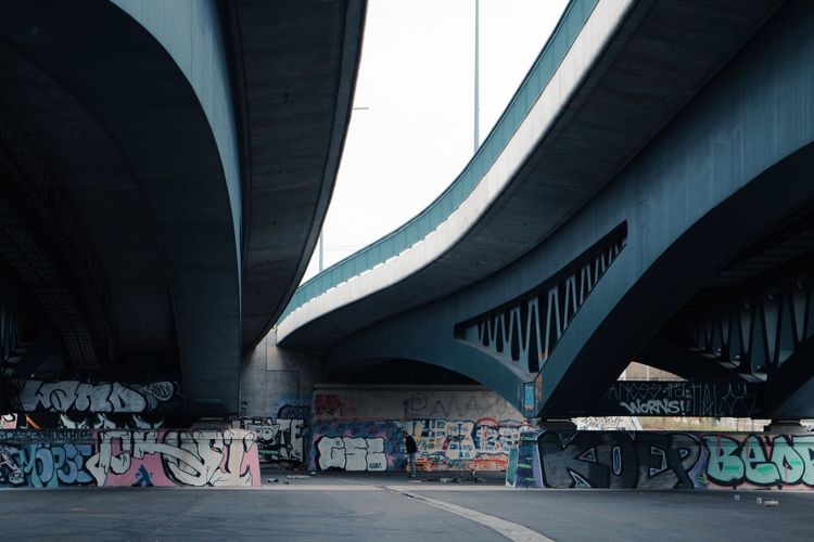 Graffiti on bridge amidst buildings in city