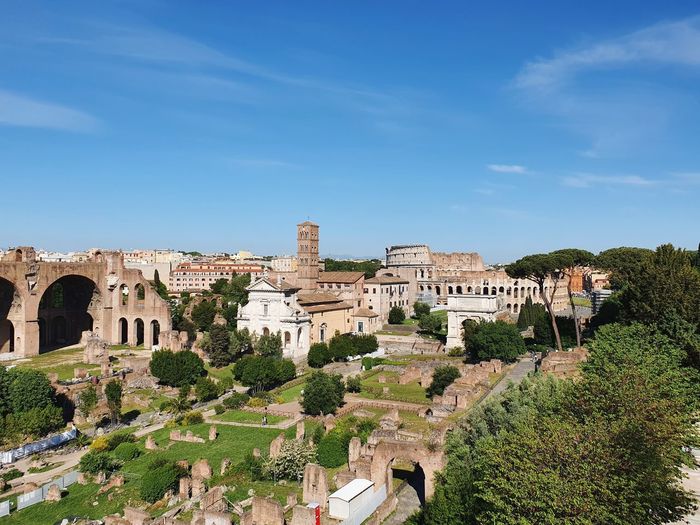 View of the foro romano with the colosseum in the back on a nice blue sky day