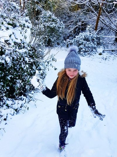 Cute girl walking on snowy field