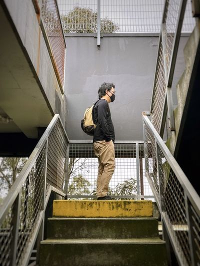 Low angle view of man on staircase against building