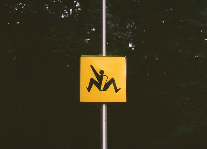 Close-up of road sign against trees