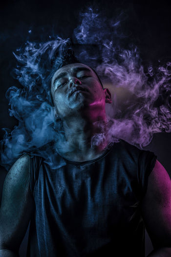 Close-up of man emitting smoke from body