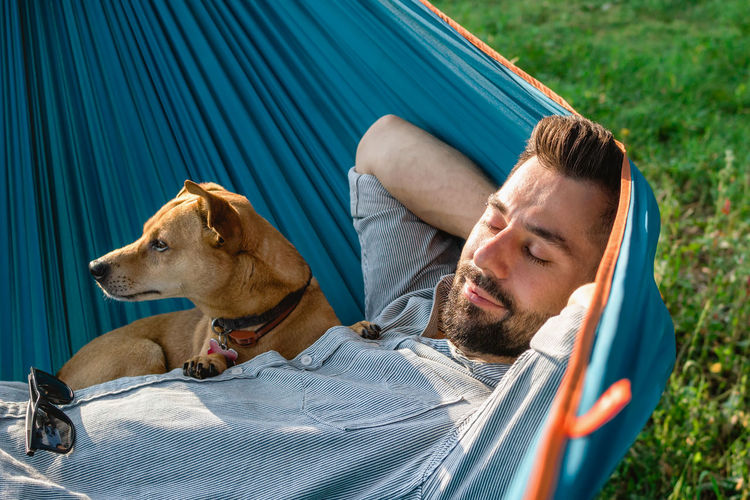 Low section of woman with dog sitting on hammock