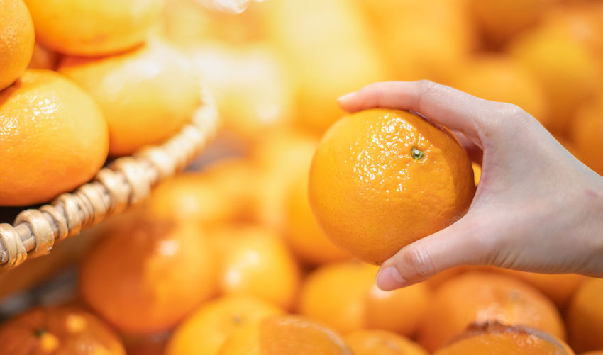 Close-up of hand holding orange fruit at market