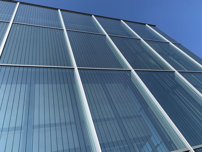 Low angle view of office building against blue sky