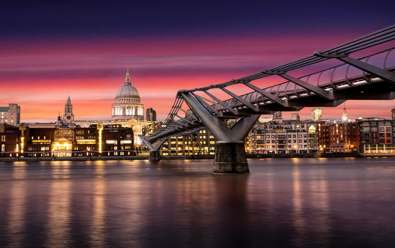 Millennium bridge by st paul cathedral against sky