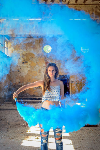 Portrait of young woman holding smoke bomb