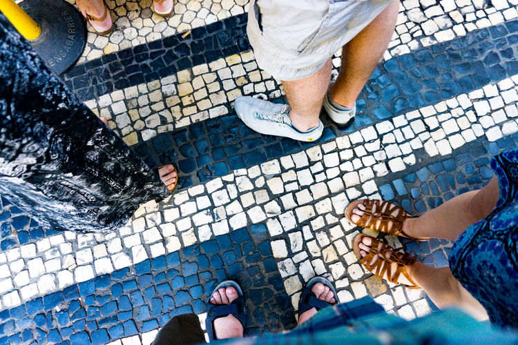 Low section of people standing on tiled floor
